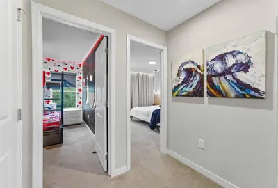 a hallway with a room with a bed and paintings at Beautiful 4BD home Themed Pool and Grill 4403 in Kissimmee