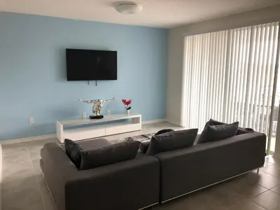 a living room with a couch and a flat screen tv at Aqua Vista Gated Resort Style Community Storey Lake in Kissimmee