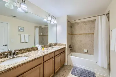 a bathroom with a tub and a sink and a bath tub at Luxury 5BR Townhome w Pool & Resort Access in Kissimmee