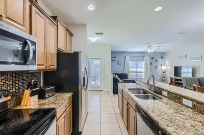 a kitchen with a sink and a stove top oven at Luxury 5BR Townhome w Pool & Resort Access in Kissimmee