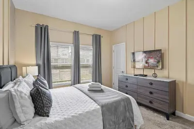 a bedroom with a bed and a dresser and a window at Relaxing Getaway Near Disney with Pool & Themed Rooms in Kissimmee