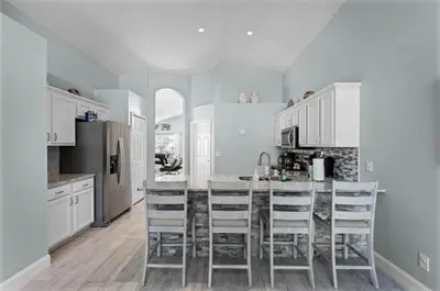a kitchen with a table and some chairs in it at Ultimate family resort home with incredible sunset views, 4 miles from Disney! in Kissimmee