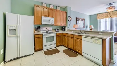 a kitchen with wooden cabinets and white appliances at Windsor Hills Resort Vacation in Orlando