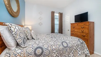 a bedroom with a bed and a dresser with a television at Windsor Palms Resort Vacation Home 5BR in Kissimmee