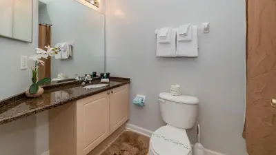 a bathroom with a toilet and a sink and a mirror at Windsor Palms Resort Vacation Home 5BR in Kissimmee