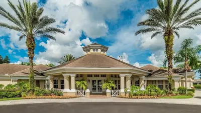 a house with palm trees in front of it at Windsor Palms Resort Vacation Home 5BR in Kissimmee