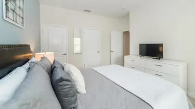 a bedroom with a large bed and a television at JLT3076 Storey Lake Resort Vacation Townhome in Kissimmee