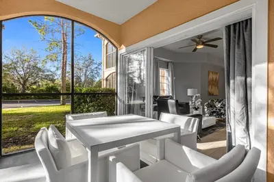 a patio with a white table and white chairs at 3 Bedroom Family Friendly Condo at WorldQuest near Disney 2714 in Orlando