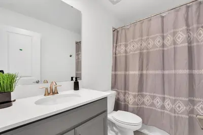 a bathroom with a sink and a toilet and a shower curtain at Serenity Lakeview Retreat Stunning Water Views, No Rear Neighbors, Private Pool, Game Room Star Wars Cinema in Kissimmee