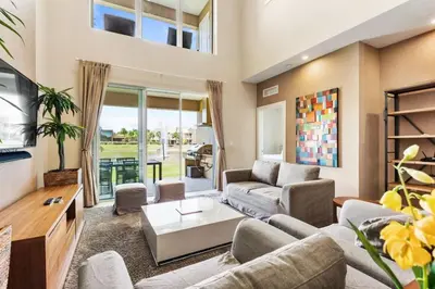 a living room with a couch and a tv at 3212 Magic Village - 8 hóspedes, à beira do lago, 8 minutos da Disney in Orlando