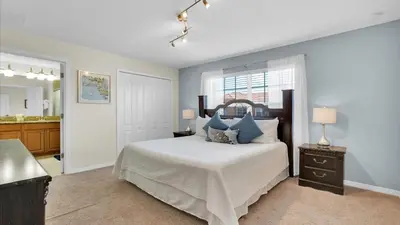a bedroom with a bed with blue pillows at CAL8959 in Kissimmee