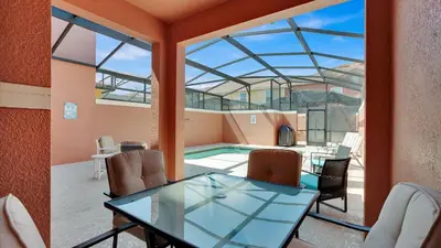 a dining room with a glass table and a swimming pool at CAL8959 in Kissimmee