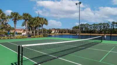 a tennis net on a tennis court with palm trees at CAL8959 in Kissimmee