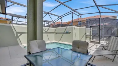 a patio with a glass table and two chairs at CAT8967 in Kissimmee