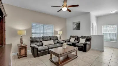a living room with leather furniture and a ceiling fan at CAT8967 in Kissimmee