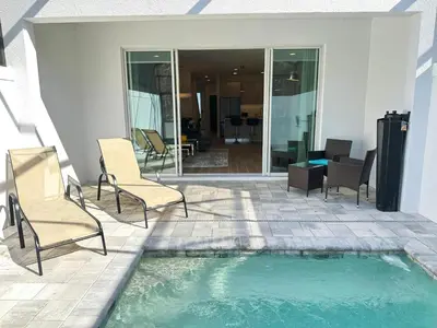 a patio with chairs and a small swimming pool at TR1433SL - Island House Orlando in Orlando