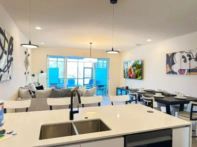a kitchen and living room with a couch and a table at TR1386PNW - 9 guests - pool home close to Disney in Clermont