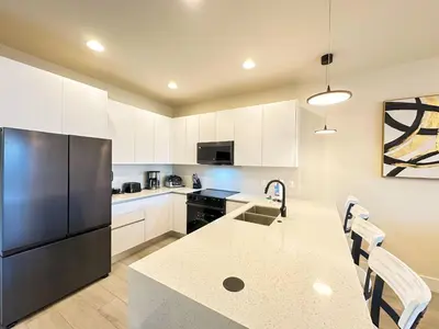 a kitchen with a black refrigerator and white cabinets at TR1386PNW - 9 guests - pool home close to Disney in Clermont