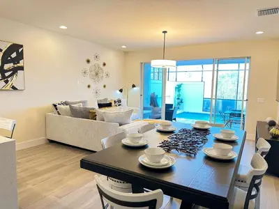 a dining room and living room with a table and chairs at TR1386PNW - 9 guests - pool home close to Disney in Clermont