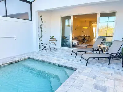 a swimming pool in a patio with chairs and a table at TR1388PNW - Modern New Home 4 Bed in Clermont