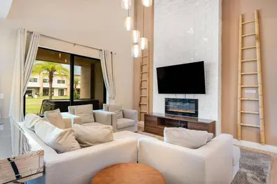a living room with white furniture and a flat screen tv at 7458 Magic Village - 8 hóspedes, jacuzzi, 8 minutos da Disney in Orlando