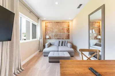 a living room with a couch and a mirror at 7458 Magic Village - 8 hóspedes, jacuzzi, 8 minutos da Disney in Orlando