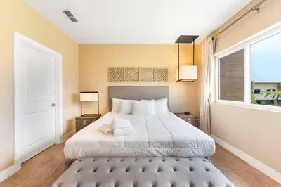 a bedroom with a large bed and a window at 7458 Magic Village - 8 hóspedes, jacuzzi, 8 minutos da Disney in Orlando