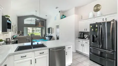 a kitchen with white cabinets and a stainless steel refrigerator at LDK2787 in Kissimmee