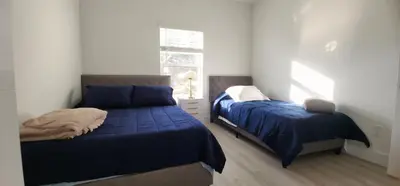 a bedroom with two beds with blue sheets and a window at Orlando Home Vacation near Universal Studios - 3 BR in Orlando