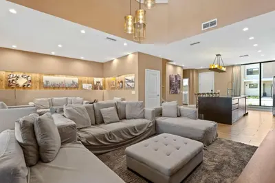 a large living room with a couch and a table at Casa 3 Suítes c/ Jacuzzi e Churrasq. — Disney 6min in Orlando