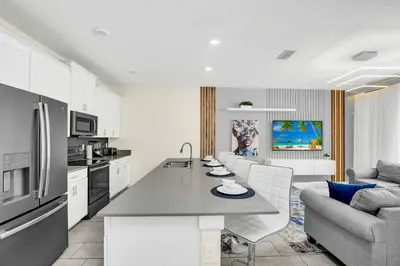 a kitchen and living room with a table and a couch at Beautiful Disney House at Storey Lake in Kissimmee