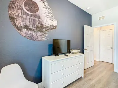 a room with a white dresser and a tv on a wall at Windsor Hills Lovely 3BR Condo Slides Pool Disney in Orlando