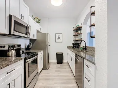 a kitchen with white cabinets and a stainless steel refrigerator at Windsor Hills Lovely 3BR Condo Slides Pool Disney in Orlando