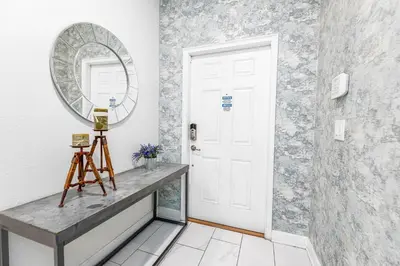 a hallway with a white door and a mirror at Amazing Townhouse TVPM in Kissimmee