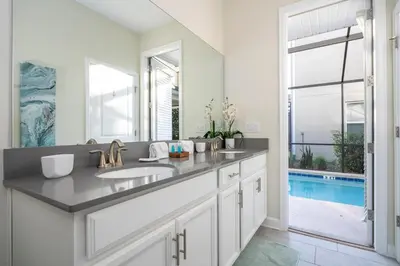 a bathroom with a sink and a mirror and a pool at Ravello Villa Storey Lake in Kissimmee