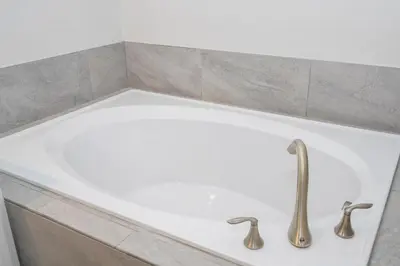 a bath tub with two faucets in a bathroom at Ravello Villa Storey Lake in Kissimmee