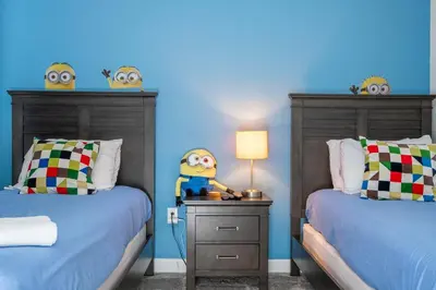 a bedroom with two beds with monsters on the wall at Ravello Villa Storey Lake in Kissimmee