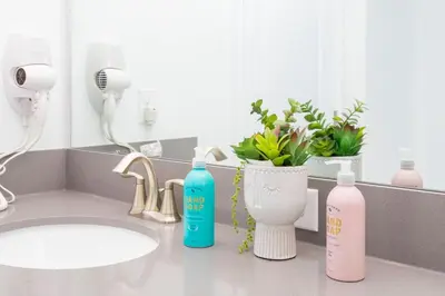 a bathroom with two bottles of soap and a sink at La Vita E Bella 4 Bedroom Storey Lake Condo in Kissimmee