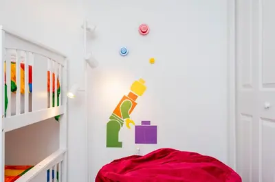 a childs room with a crib and a wall with aigger sticker at La Vita E Bella 4 Bedroom Storey Lake Condo in Kissimmee