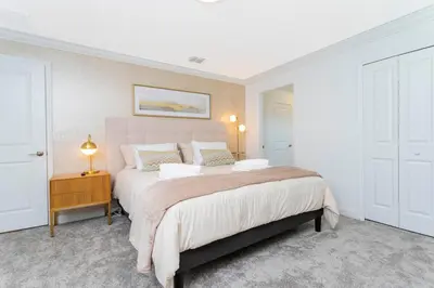a white bedroom with a large bed and a table at La Vita E Bella 4 Bedroom Storey Lake Condo in Kissimmee