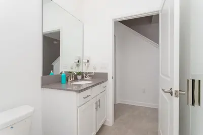 a white bathroom with a sink and a mirror at La Vita E Bella 4 Bedroom Storey Lake Condo in Kissimmee