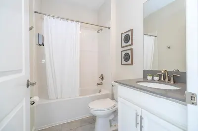 a white bathroom with a toilet and a sink at Villa Paradiso at Storey Lake in Kissimmee