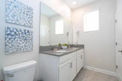 a white bathroom with a sink and a mirror at Villa Paradiso at Storey Lake in Kissimmee