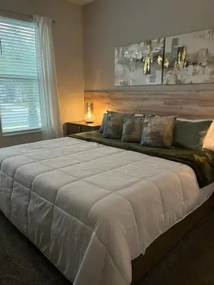 a large white bed in a bedroom with a window at Villa Paradiso at Storey Lake in Kissimmee
