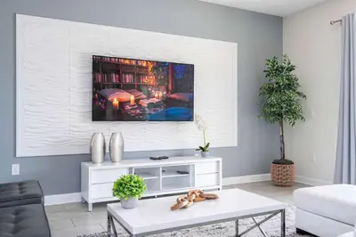 a living room with a tv on the wall at Stunning Game Room & Pool Jacuzzi Storey Lake 2799 in Kissimmee