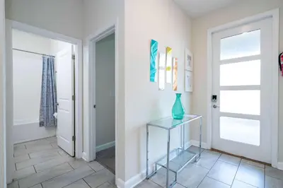 a hallway with a glass vase on a glass table at Stunning Game Room & Pool Jacuzzi Storey Lake 2799 in Kissimmee