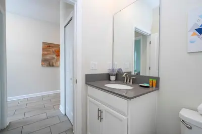 a bathroom with a sink and a mirror at Stunning Game Room & Pool Jacuzzi Storey Lake 2799 in Kissimmee