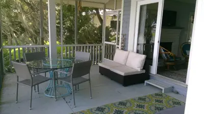 a porch with a glass table and chairs and a couch at Lakefront with Dock on Private Lake Florence near Montverde Academy in Montverde
