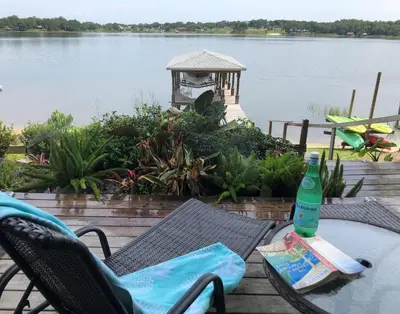 a bottle of water sitting on a table next to a lake at Lakefront with Dock on Private Lake Florence near Montverde Academy in Montverde