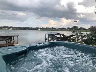 a jacuzzi tub in front of a body of water at Lakefront with Dock on Private Lake Florence near Montverde Academy in Montverde